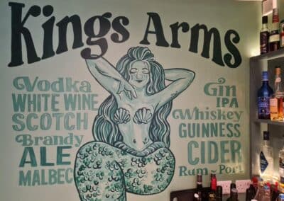 The King Arms sign with an illustrated mermaid and available drinks