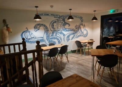 Inside The Kings Arms, a view of the seating area, with a huge octopus illustration on the wall.