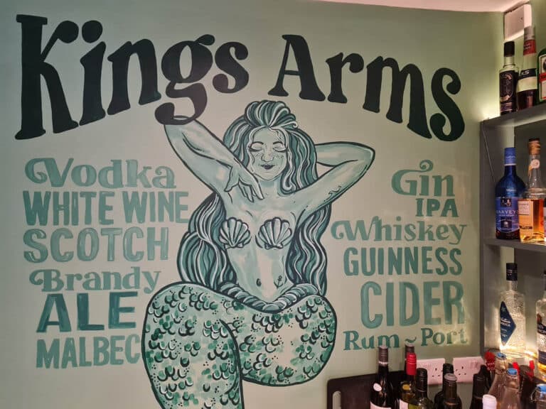 The King Arms sign with an illustrated mermaid and available drinks