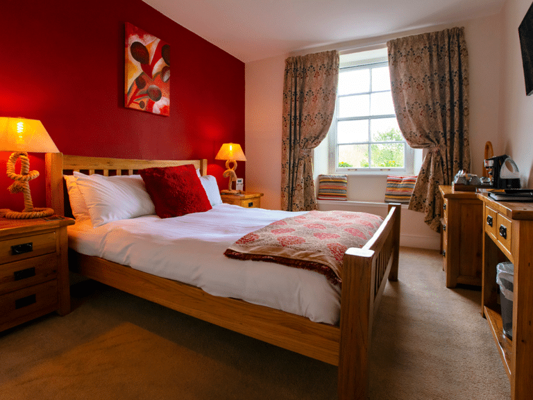 The Ship in Dock Inn Bedroom. A lovely double bed room with dark red decor.